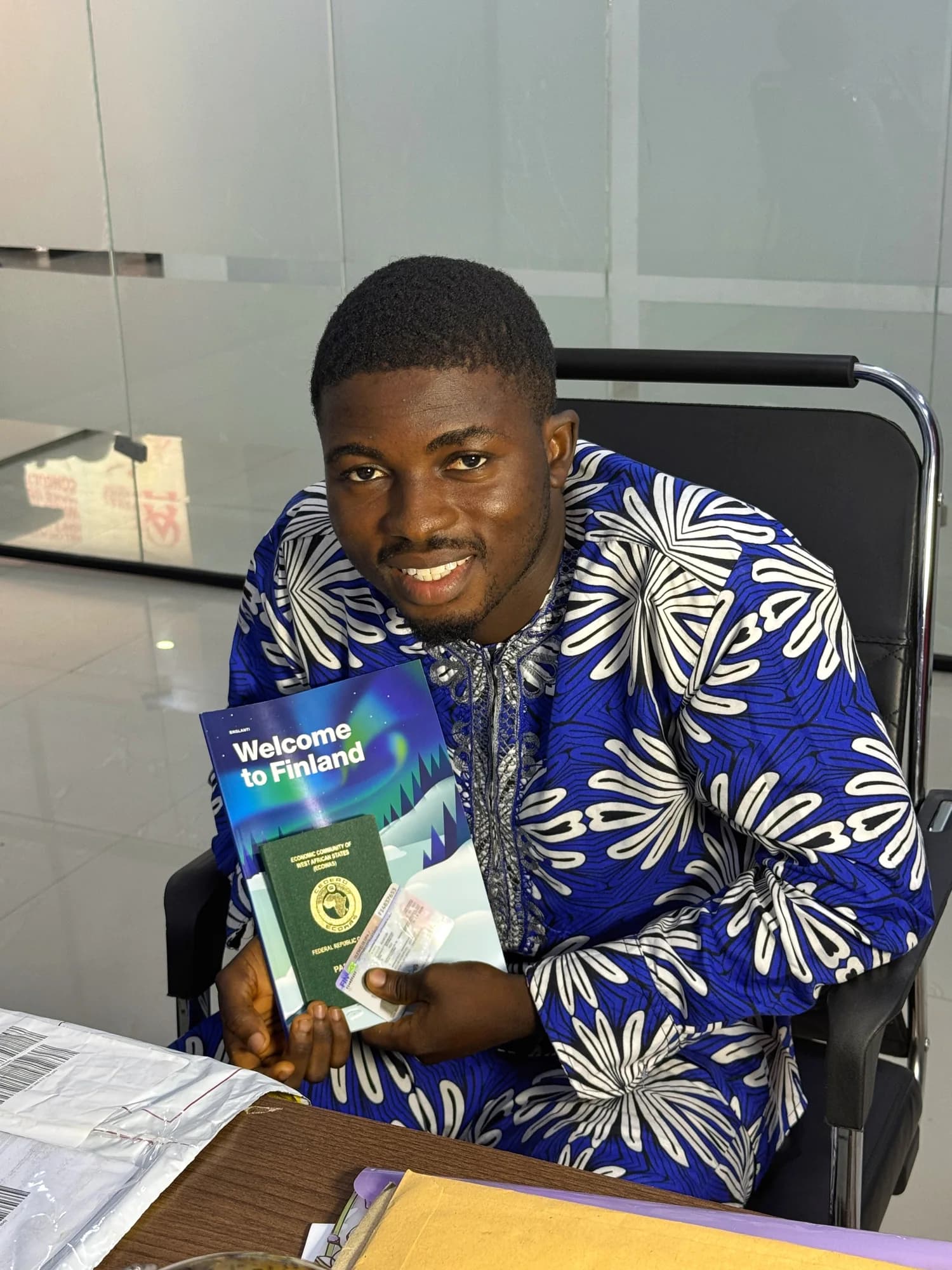 A client smiling while holding travel documents